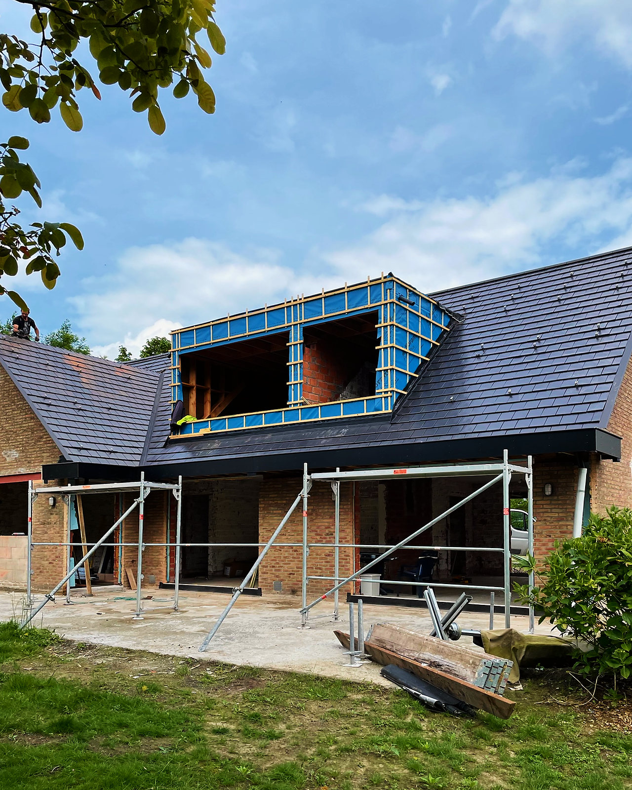 De woning in de stelling: het dak al in leizwarte pannen, de dakkapel nog in opbouw.