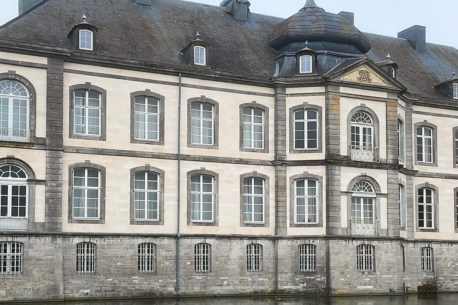 Het kasteel met zijn leiendaken, gezien over het water.