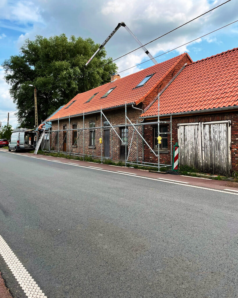 De boerderij in de stelling, met de nieuwe rode pannen op het dak.