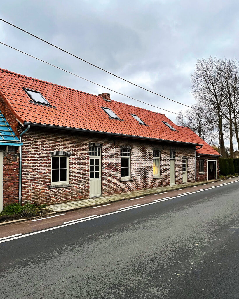 Zicht vanaf de straat op het afgewerkte dak in rode pannen.