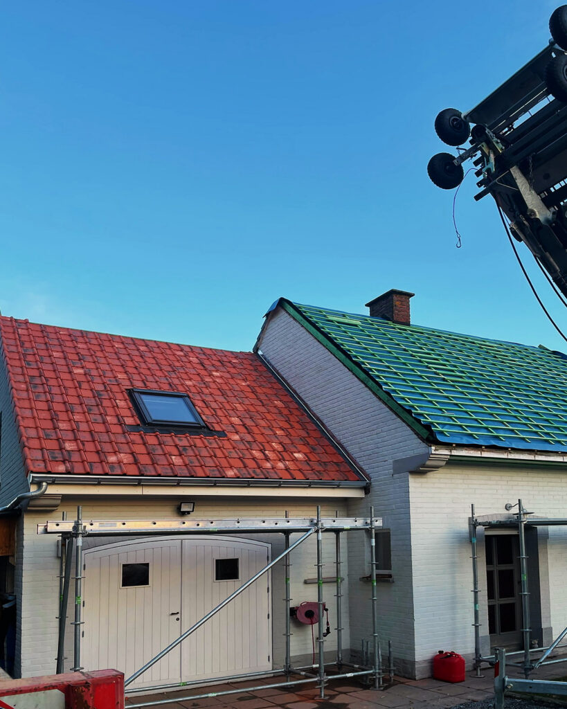 De ladderlift brengt materiaal naar het dak, naast het nieuwe onderdak.