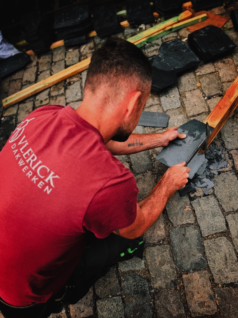 Een vakman in een Vlerick-shirt bewerkt een natuurlei op de werf.